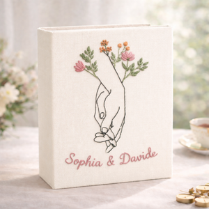 Personalized holding hands hand embroidered photo album with floral accents and custom names on linen cover