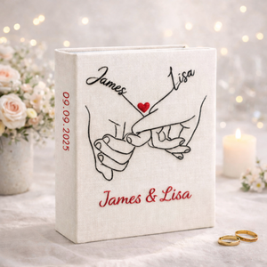 Personalized holding hands hand embroidered photo album with floral accents and custom names on linen cover