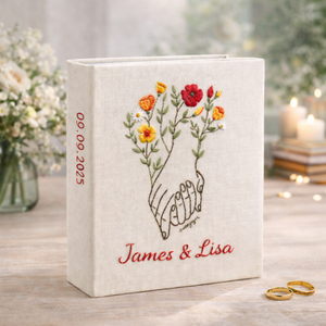 Personalized holding hands hand embroidered photo album with floral accents and custom names on linen cover