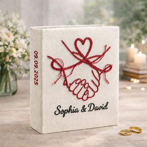Personalized holding hands hand embroidered photo album with floral accents and custom names on linen cover