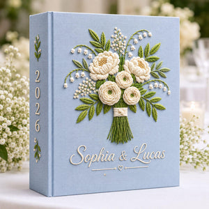 Personalized white floral bouquet hand embroidered photo album with custom names on blue linen wedding keepsake cover