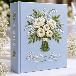 Personalized white floral bouquet hand embroidered photo album with custom names on blue linen wedding keepsake cover