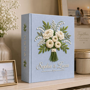 Personalized white floral bouquet hand embroidered photo album with custom names on blue linen wedding keepsake cover